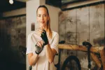 Frau bereitet sich mit Handschuhen in einer Fitnessumgebung mit Holzelementen vor