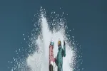 Zwei Personen, die durch Wasser spritzen und ski fahren