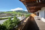 Sonniger Balkon mit grünen Hügeln und blauem Himmel