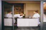 Zwei Personen in Bademänteln führen ein Gespräch am Tisch