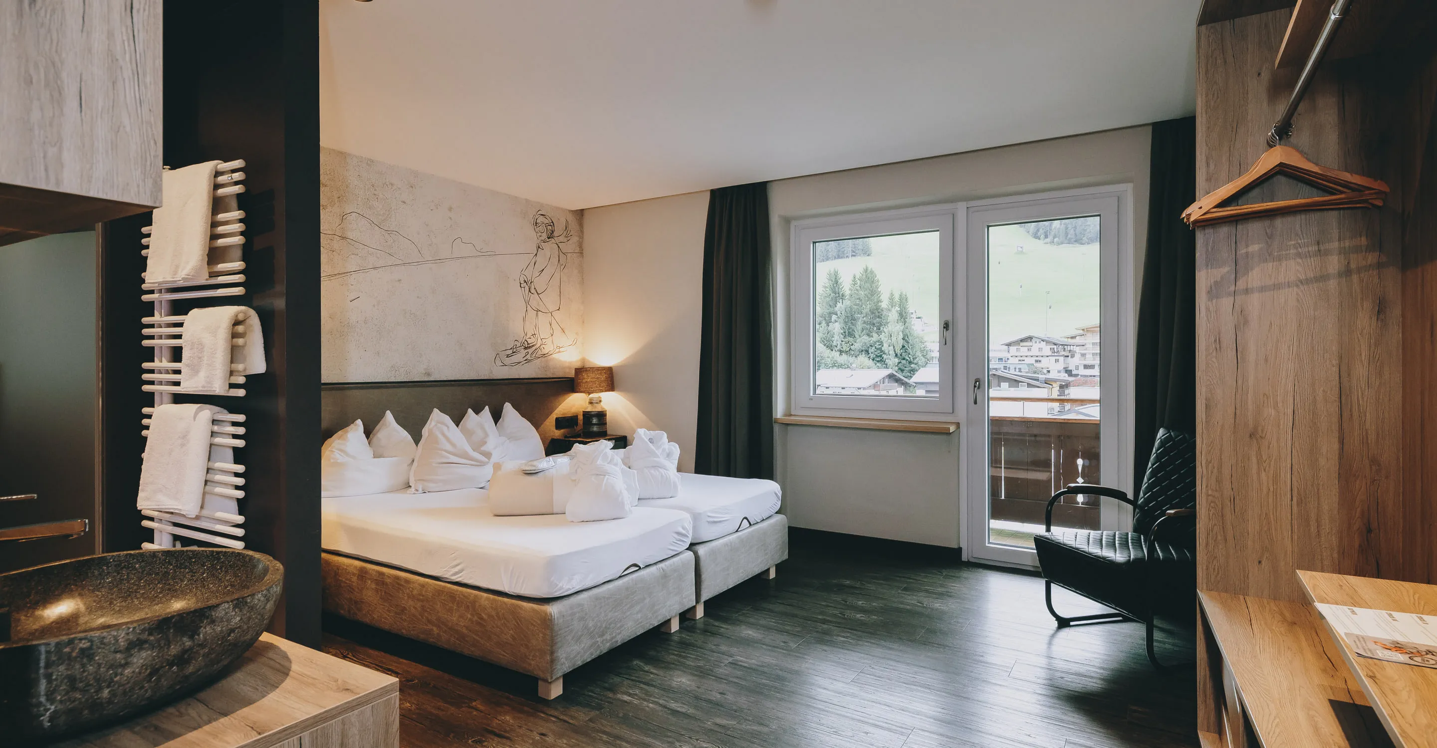 Helles Zimmer mit Doppelbett, Balkon und moderne Einrichtung.