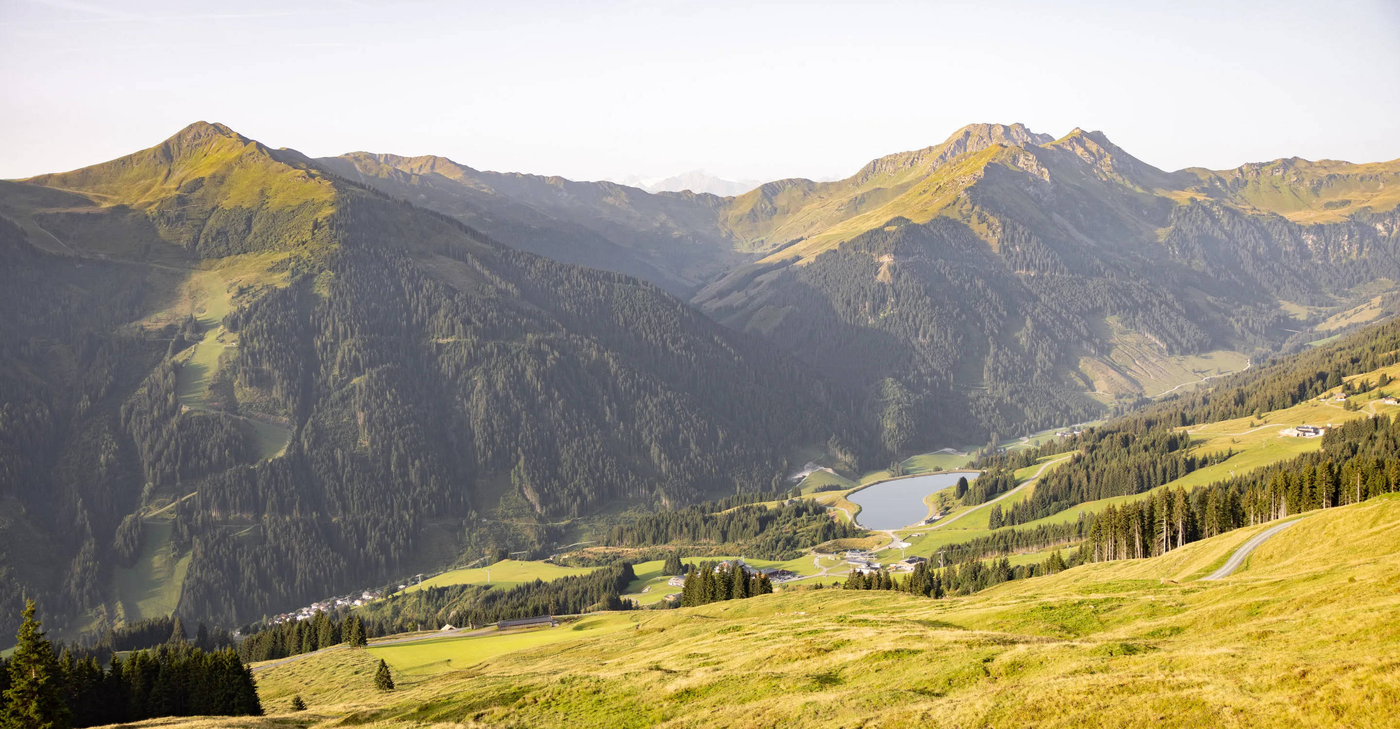 Berglandschaft mit grünen Hügeln und einem Fluss im Sommer