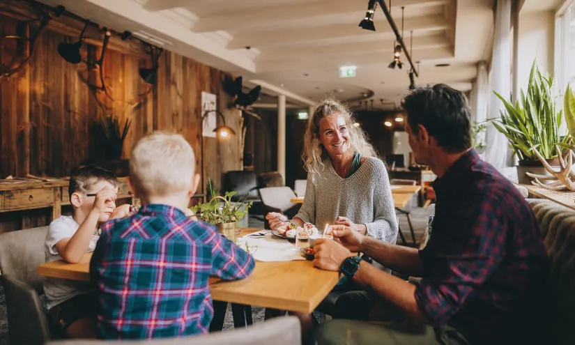 Familie beim Essen in einem Restaurant mit Holzdekor