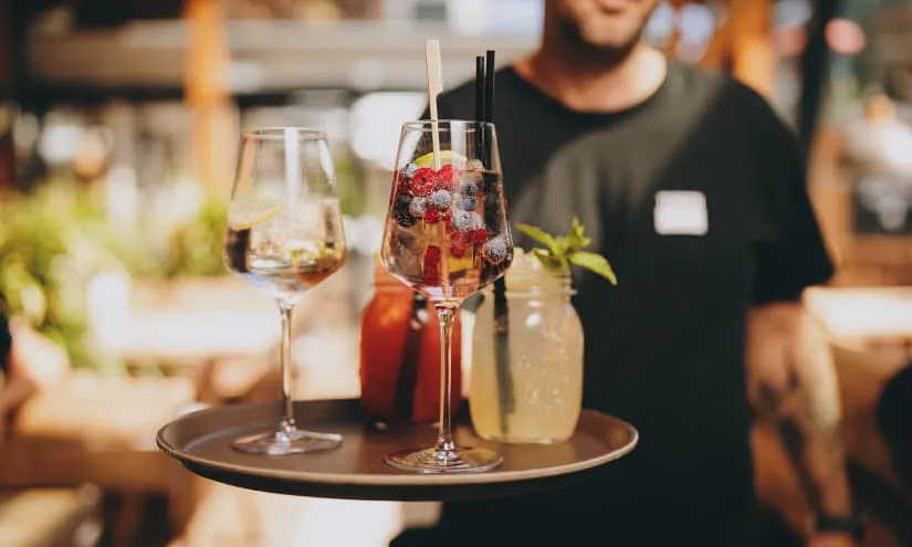 Tablett mit Getränken in Thomsn-Hinterglemm, darunter Cocktails und Wasser.