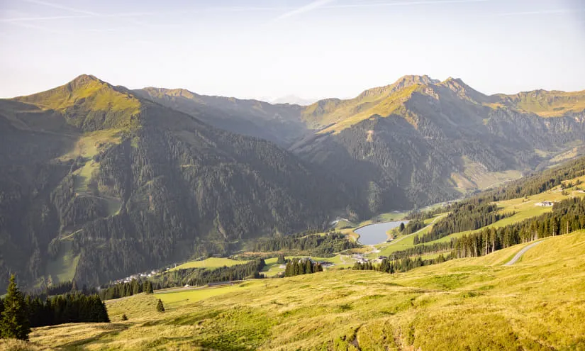 Sommerlandschaft mit Bergen und einem Fluss im Tal