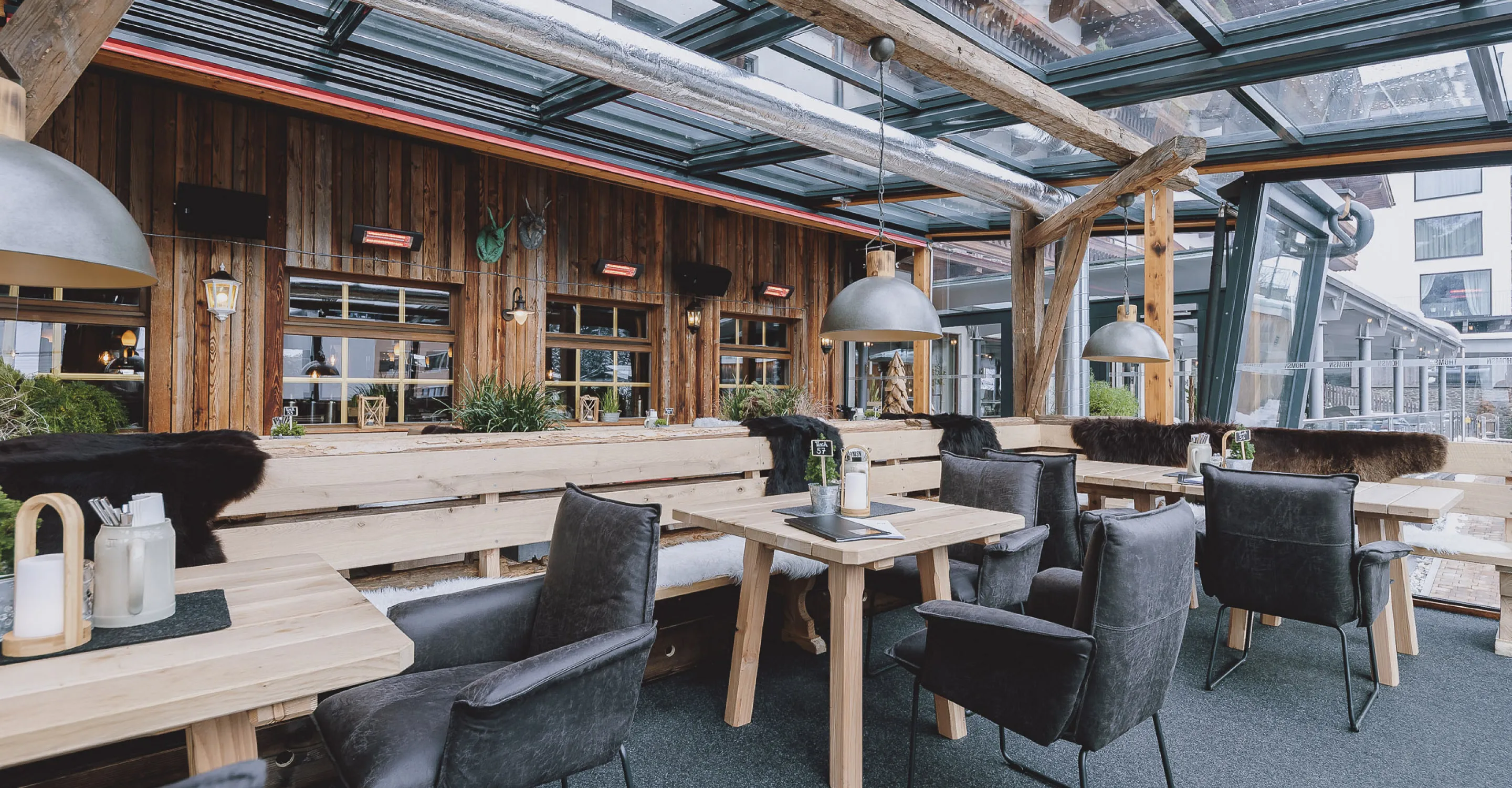 Moderne Terrasse mit Holzmöbeln und großem Glasdach