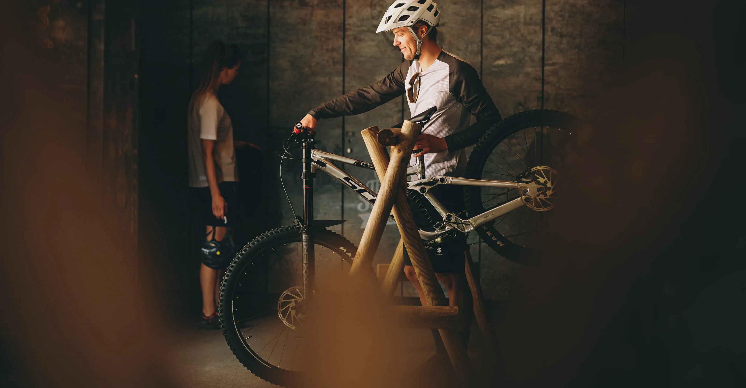 Mann mit Fahrrad in Thomsn Hinterglemm, Frau im Hintergrund.
