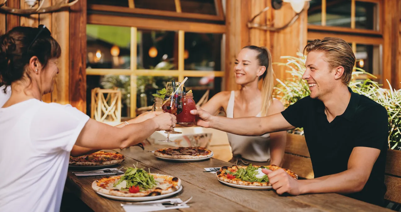 Friends toasting at a restaurant in Thomsn-Hinterglemm.
