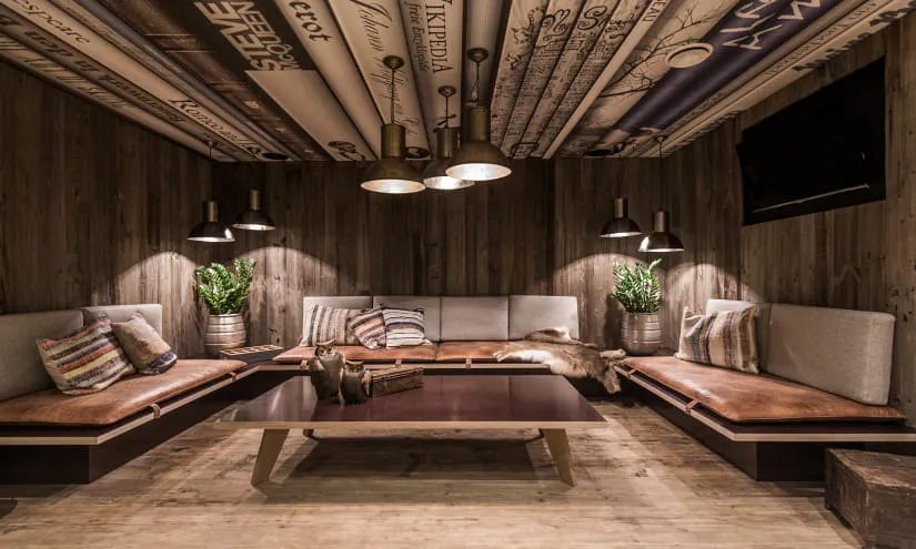 Gemütlicher Lounge-Bereich im THOMSN Alpiner Rock Hotel mit Holzstruktur und Pflanzen.