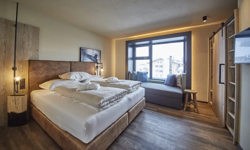 Helles Hotelzimmer mit Doppelbett und großem Fenster.
