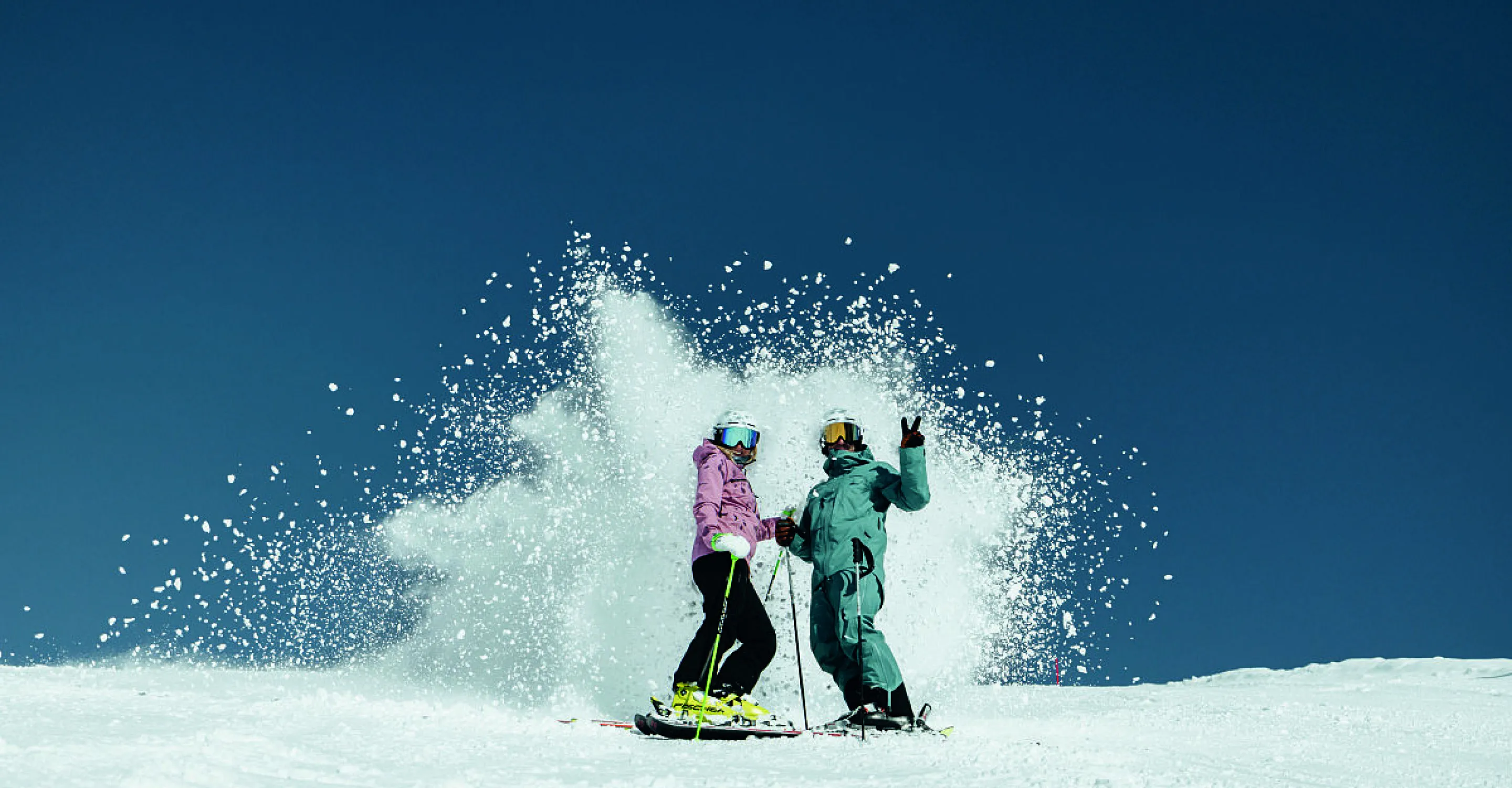 Zwei Skifahrer im Skicircus Saalbach Hinterglemm Leogang Fieberbrunn, Schnee spritzt.