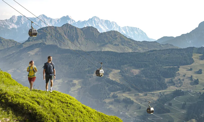 Wanderer in Saalbach Hinterglemm mit Seilbahn im Hintergrund
