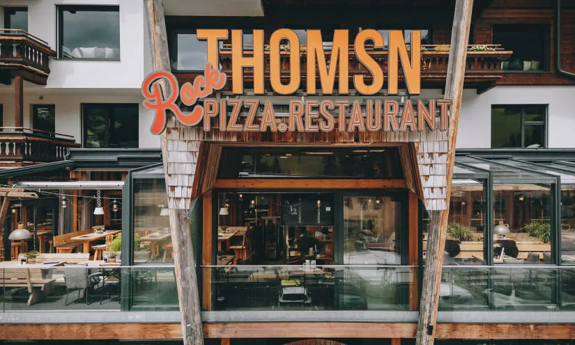 Restaurantfassade von THOMSEN mit Außenbereich und Beschriftung.
