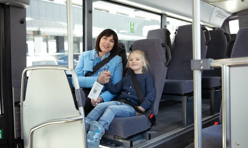 Woman and child in a bus holding a ticket