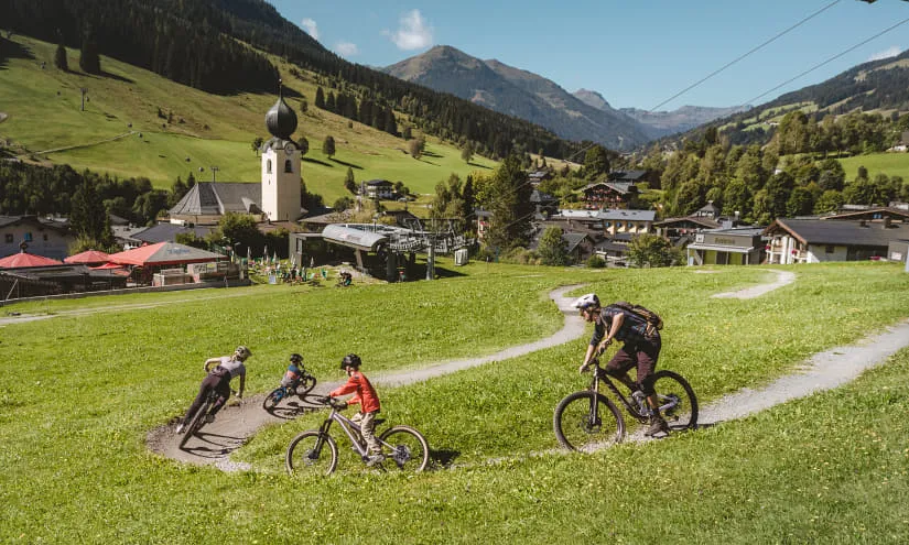Vier Radfahrer fahren auf einem Dirttrack im grünen Tal.